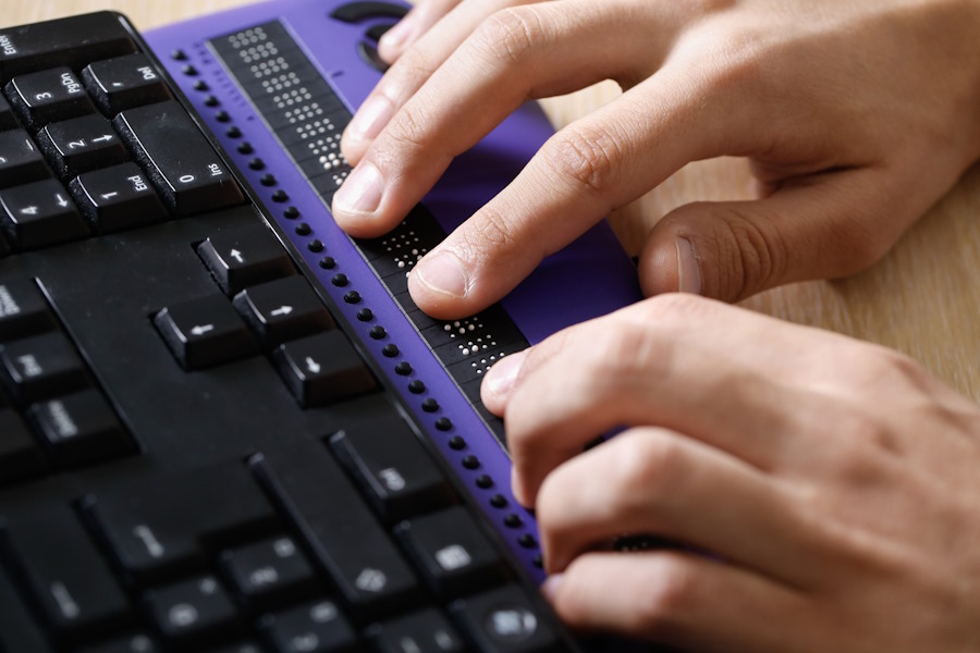 Blind person using computer with braille computer display