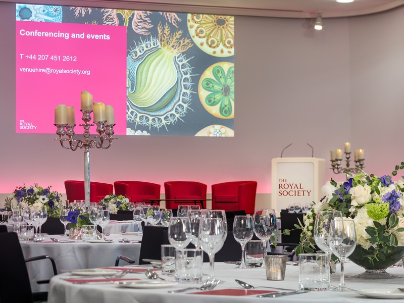 Tables set for dinner, looking onto the Royal Society panel chairs.