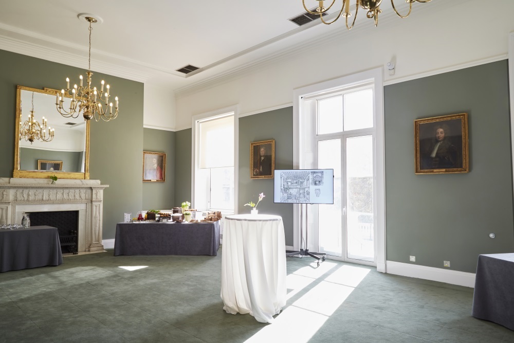 The reception room with assorted tea, coffee and pastries displayed on a corner table.