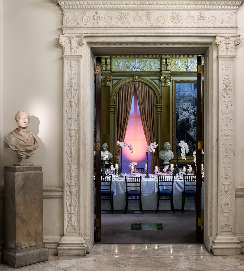 Tables adorned with dinner sets, looked on from outside the room.