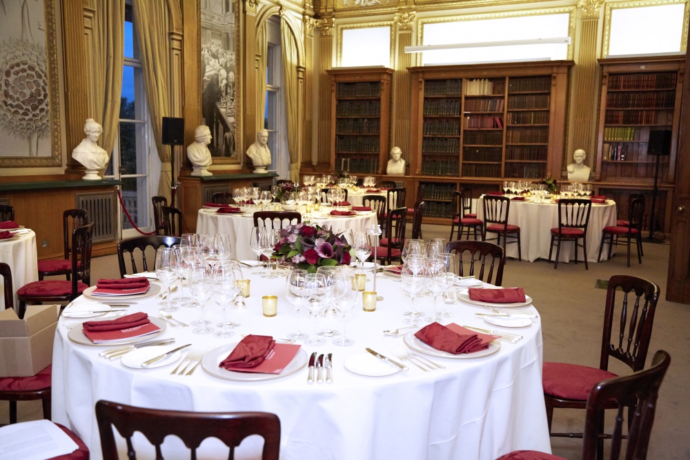 White tables adorned with dinner sets.