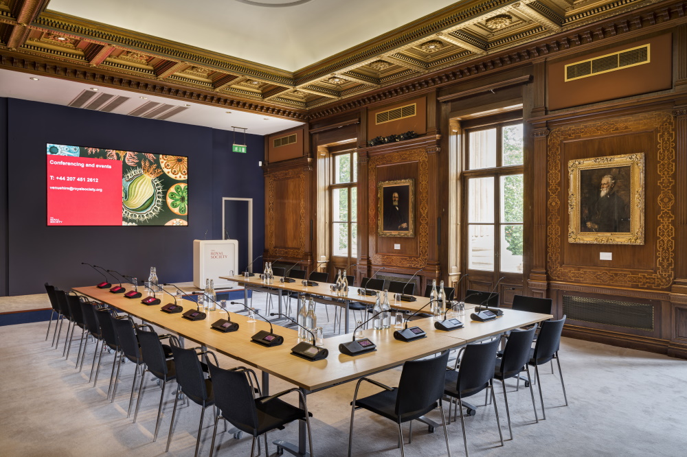 A large U-shape table facing a projector screen.