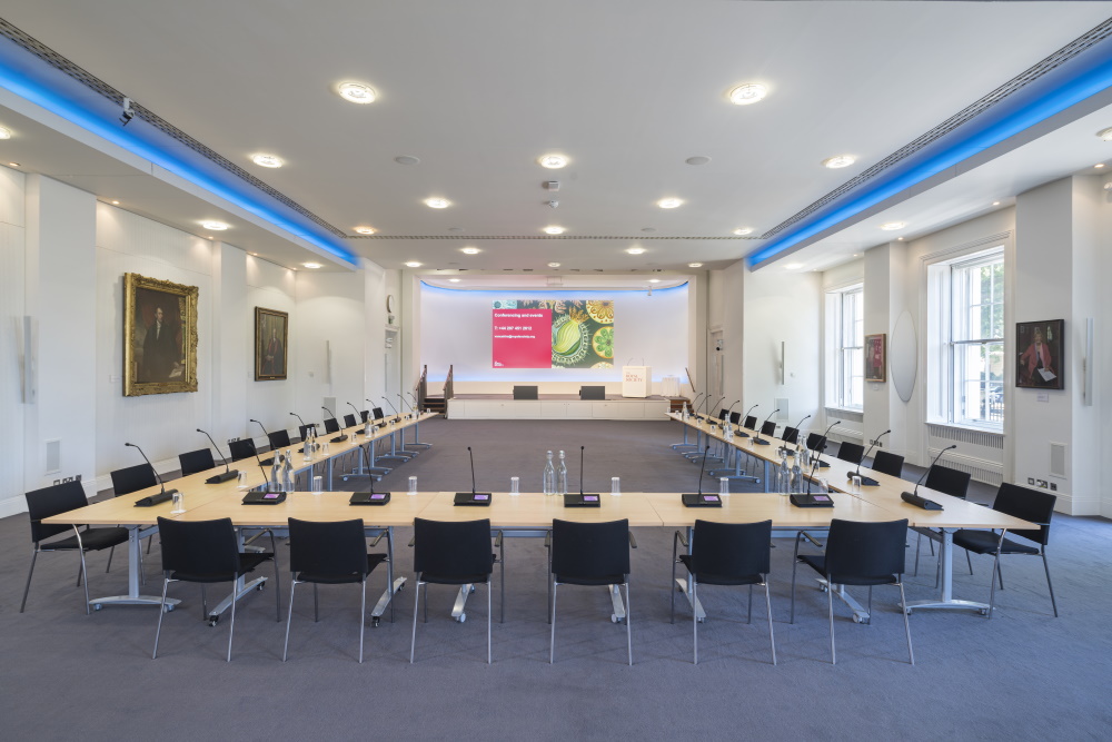 A large U-shape table, with microphones at each seat.